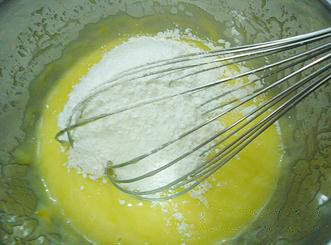 柠檬小蛋糕,倒入提前混合并筛过的<a style='color:red;display:inline-block;' href='/shicai/ 548'>低筋面粉</a>和泡打粉，用打蛋器拌匀至没有面粉颗粒。