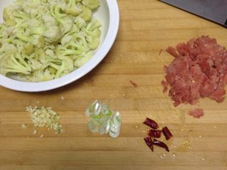 肉炒菜花,菜花掰好，焯过水，过凉水，肉切成小片，葱切片，蒜切成沫，辣椒掰两半