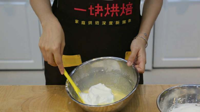 北海道戚风蛋糕,将三分之一的蛋白糊加入蛋黄糊后翻拌均匀