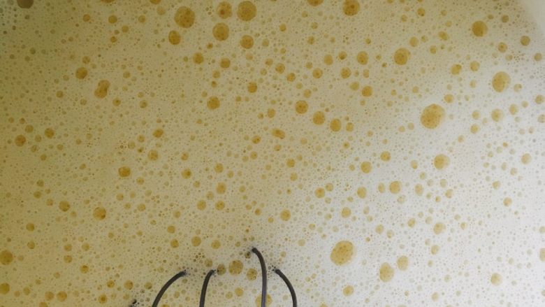 芒果千层,一边加入牛奶一边用手动打蛋器搅拌均匀