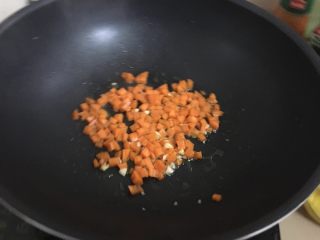 黄金蛋炒饭,热锅热油放点蒜蓉，然后放胡萝卜翻炒。炒到七成熟就放火腿芹菜翻炒。记得放点盐。