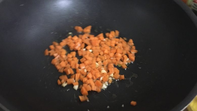 黄金蛋炒饭,热锅热油放点蒜蓉，然后放胡萝卜翻炒。炒到七成熟就放火腿芹菜翻炒。记得放点盐。