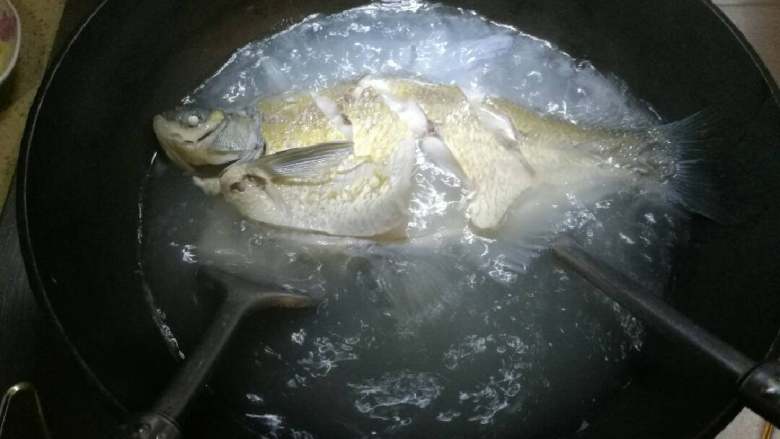葱油鳊鱼,用炊具把鱼盛起，为防止鱼肉散架，可以用2把烦具。