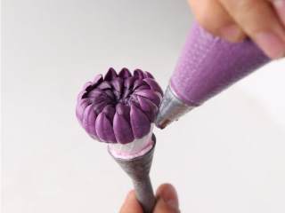 裱花蛋糕,奶油调成深紫色，用森派8号菊花嘴在糯米托上由外向内挤出弧形花瓣，约4层，作为花心，花心要包成凹形。