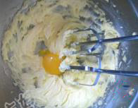 蓝莓杏仁软曲奇,完全软化的黄油加入糖粉，用电动打蛋器搅打至微微发白，分次加入蛋黄，每次都搅拌至被黄油完全吸收。
