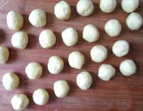 蓝莓杏仁软曲奇,用手把颗料状的饼干粉抓捏成团，并称出15克每个重量的面团。