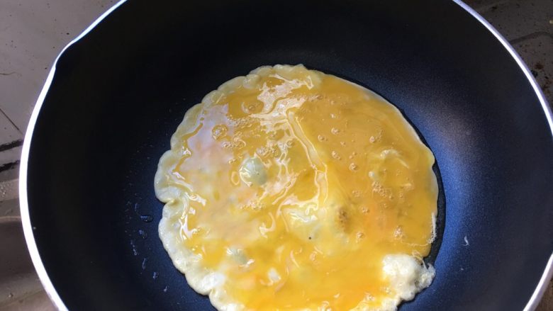 鸡蛋炒饭,锅中放油，放入鸡蛋液炒熟。