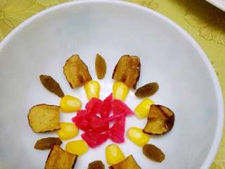 #年夜饭#八宝糯米饭,取一个深碗，底部放入玫糖、玉米粒、葡萄干、红枣丝摆放成型。