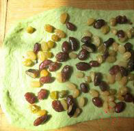橄榄油抹茶蜜豆吐司,松驰好的面团擀成长方形的片状，撒上蜜豆。