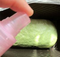橄榄油抹茶蜜豆吐司,把面坯放入土司模具里，在土司模里喷些水，盖上保鲜膜进行最后发酵。