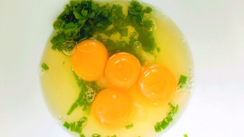 三分钟搞定小盆友快手早餐的鸡蛋卷,小葱切成0.5cm左右小段，放入四个<a style='color:red;display:inline-block;' href='/shicai/ 9'>鸡蛋</a>。
