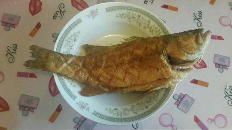 纸包鲈鱼,在鲈鱼的表面拍面粉炸至两面金黄，可以火候稍微大一些没关系，这样做出来的鱼外焦里嫩。