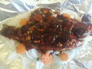 纸包鲈鱼,把准备好了的胡萝卜片和香菇摆放好，然后再把调好的酱汁从头到尾淋在鱼身上。