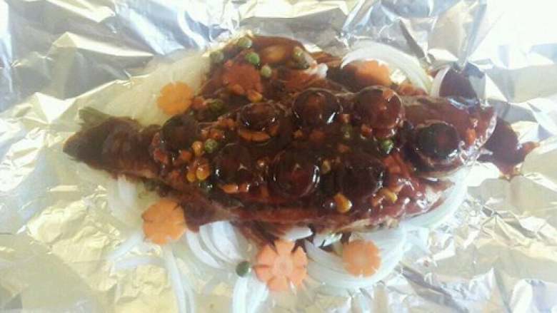 纸包鲈鱼,把准备好了的胡萝卜片和香菇摆放好，然后再把调好的酱汁从头到尾淋在鱼身上。