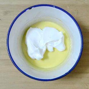 百香果戚风蛋糕,将蛋白分三次加入到蛋黄糊中，用刮刀切拌均匀。