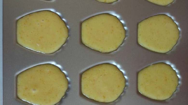 香橙玛德琳,冷藏后的面粉糊会凝固，在常温放置到液态就可以装盘了，可以用裱花袋，也可以用勺子