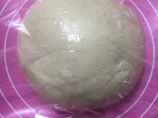 豆沙大理石吐司,整圆后置于案板上发酵，盖上保鲜膜约1小时