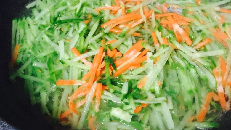 萝卜丝海米饺子#有个故事#,把萝卜、胡萝卜擦成丝、锅中放入清水烧开、放一勺盐、把擦好的萝卜丝和胡萝卜丝焯水、记得多焯一下……