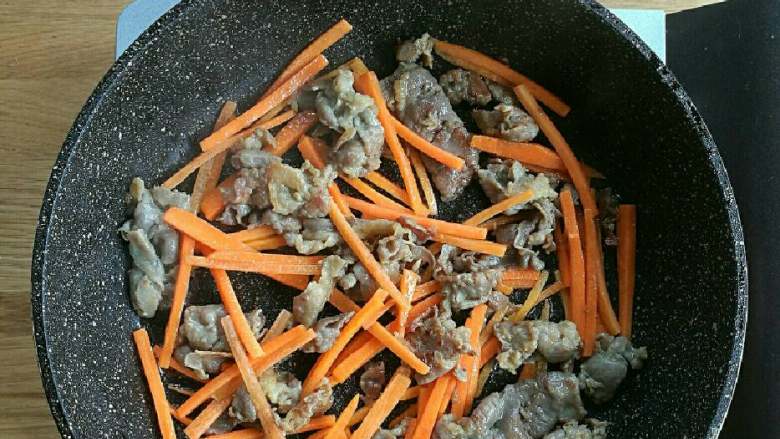 牛肉泡菜糙米饭,锅中高火加热，倒入少许油，倒入肥牛肉片炒至半熟，然后倒入胡萝卜丝一分钟。