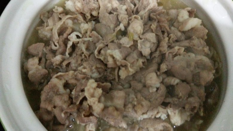 酸汤肥羊煲,把烫熟的羊肉卷连同汤汁一起倒入盛有酸菜金针茹的砂锅中。
