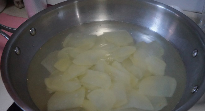 响油土豆片,锅中放水，水烧开后加入4克食盐，然后把土豆片放入焯1.5-2分钟。