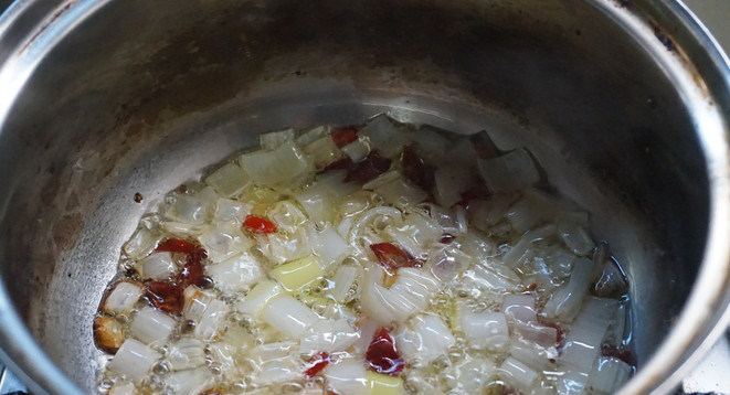 响油土豆片,锅中热油，把大葱和辣椒粒爆出香味。