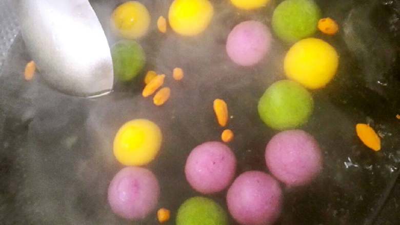 彩色花生芝麻汤圆+#春意绿#,水烧开，放入汤圆，用圆头勺子搅下，防止沉底粘锅