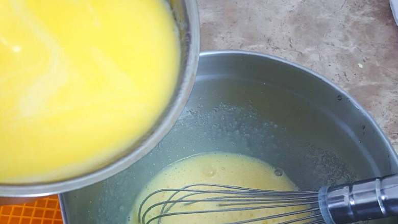 无敌巨好吃の奶酪华夫饼,混合牛奶液与蛋液。左手将牛奶液缓慢、少量多次的倒入蛋液中，同时右手蛋抽一直搅打蛋液，注意避免一次性倒入太多以致烫熟蛋液。