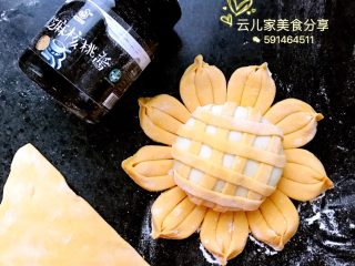 向日葵包子,取一块南瓜面擀成薄饼，用刀切成条状，如图裹在白面上面