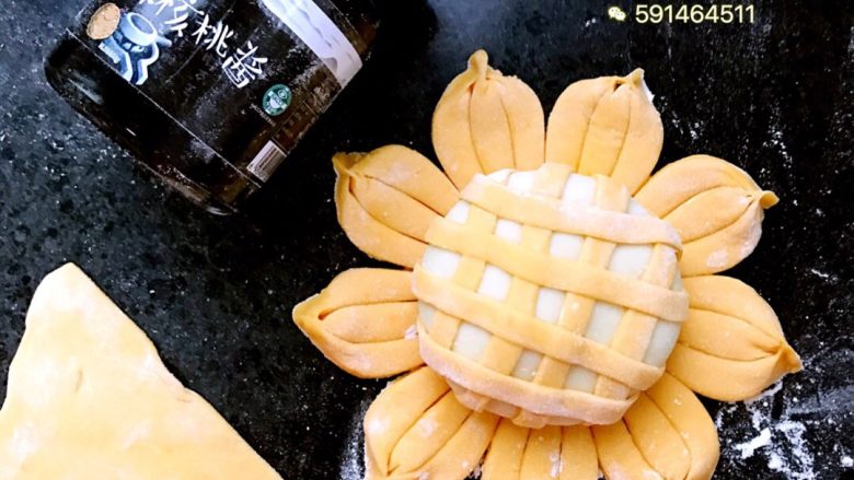 向日葵包子,取一块南瓜面擀成薄饼，用刀切成条状，如图裹在白面上面