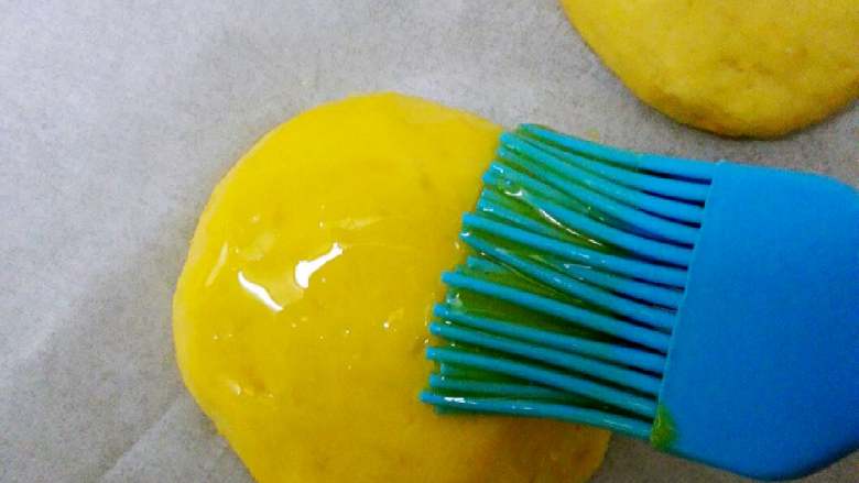 奶酪地瓜饼+#有个故事#,瓜饼放在烤盘上，表面刷上一层蛋黄液。