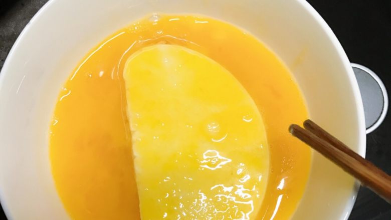 黄金馍片,调好的蛋液别忘了放盐喔，
把馒头片浸泡在蛋液内，涂抹均匀后下锅油炸