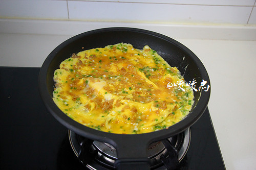 菜脯蛋,缓缓倒入打匀的鸡蛋液，中小火煎至一面定型后后翻面。