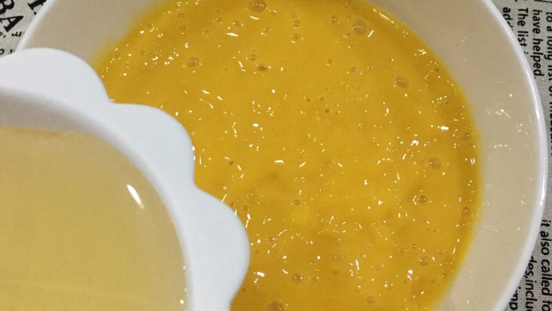 免烤芒果慕斯蛋糕,将吉利丁片和芒果泥混合，搅拌均匀备用。