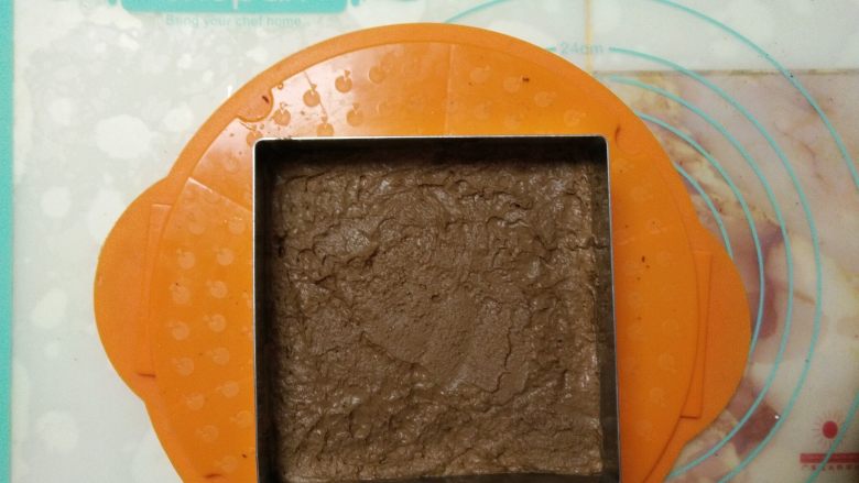 双色巧克力慕斯蛋糕,把拌好的慕斯液倒入放了蛋糕片的模具中，入冰箱冷冻一小时。