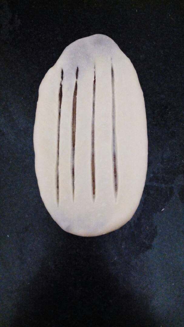 ≈豆沙卷面包≈,擀成椭圆形，用刀划几道