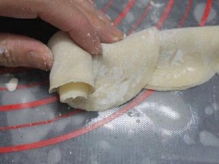 玫瑰花煎饺,将对折的饺子皮，从一端轻微的卷起，卷好接口处，捏好，保证地步平坦