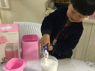 自制草莓酸奶,将牛奶倒入奶罐中
