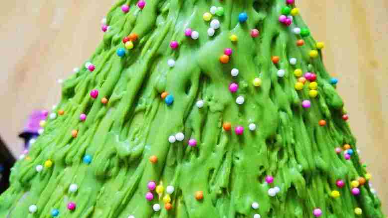 3D圣诞树#乐享双节#,再快速撒上彩虹糖，让其粘在上面，