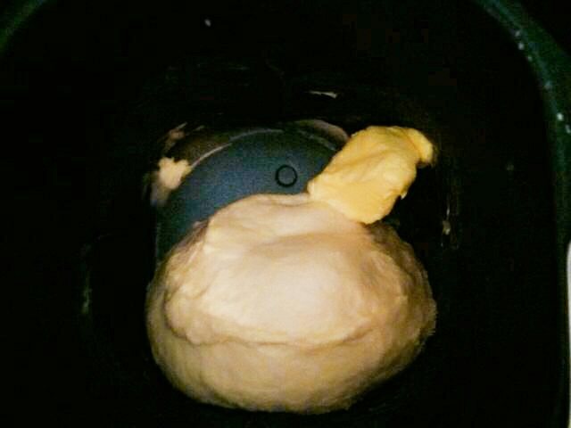 小熊面包+#乐享双节#,将黄油放进揉好的面团，继续揉面模式