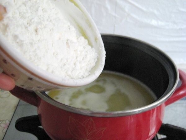 迷你小泡芙,把过筛好的面粉倒入锅中快速搅拌，搅拌至均匀