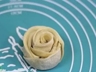玫瑰花煎饺,从一端卷起，末尾交接出沾点水粘连稳固，这样就成了一朵玫瑰花
