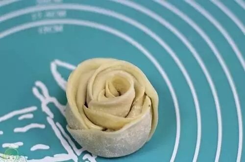 玫瑰花煎饺,从一端卷起，末尾交接出沾点水粘连稳固，这样就成了一朵玫瑰花