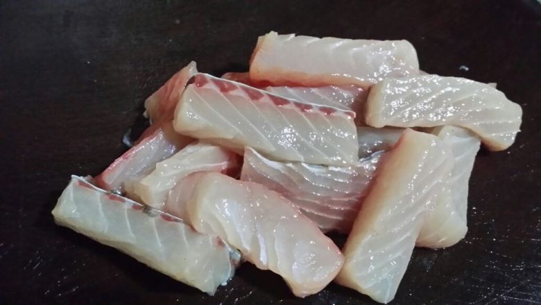炸鲩鱼块,鱼肉洗净切成长方条块，加少许盐抓拌腌制。