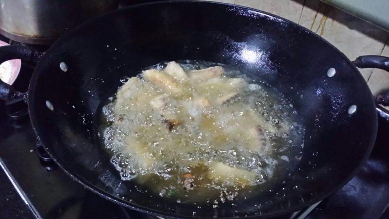 炸鲩鱼块,锅烧热，加入花生油煮至约90度，将鱼块逐块放入油中，硬结后不时翻动，炸至略呈金黄色。