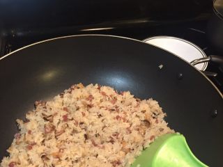 生炒腊味糯米饭,如是这般再炒半个小时米就熟了，这时放一汤匙生抽和少许香油糖葱花香菜翻炒均匀。