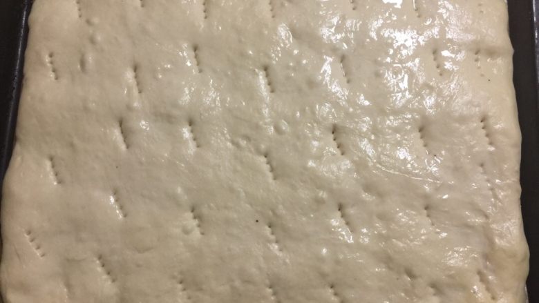 花生酱面包卷#乐享双节#,将面团擀成长方形，发酵至原来的两倍大以后用叉子叉出小孔。