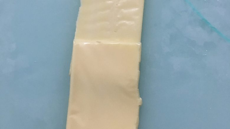 乳酪火腿面包,面团松弛期间我们来做馅料：把乳酪片对半切开，两片叠放在一起，放上<a style='color:red;display:inline-block;' href='/shicai/ 8817'>脆皮肠</a>。