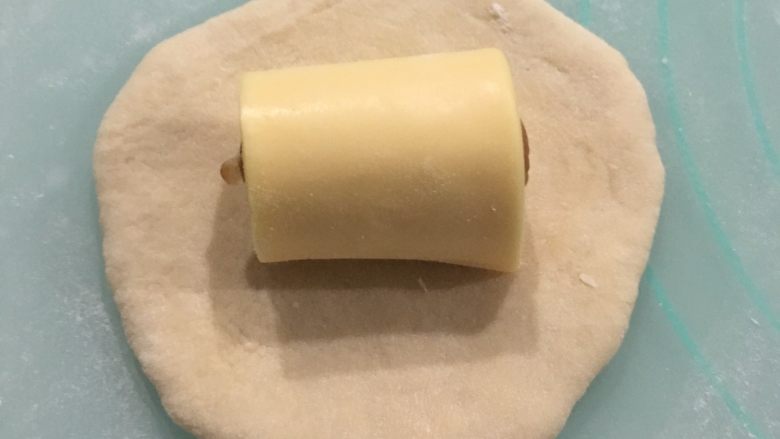 乳酪火腿面包,取一面团擀成圆片，放入一个馅料，像包包子一样包好，捏紧收口。