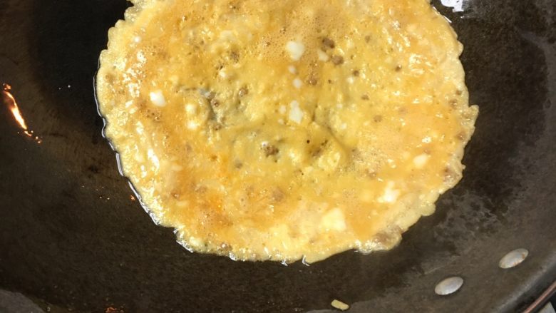 蛋包饭,锅里加入少许油，将蛋液摊成饼状